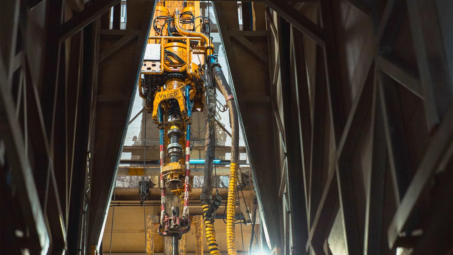 A top drive peeks through a shadowed structure